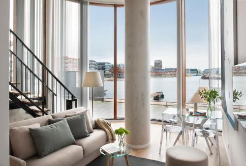 Eric Vökel Boutique Apartments - Riverfront Suites في أمستردام: غرفة معيشة مع أريكة وطاولة