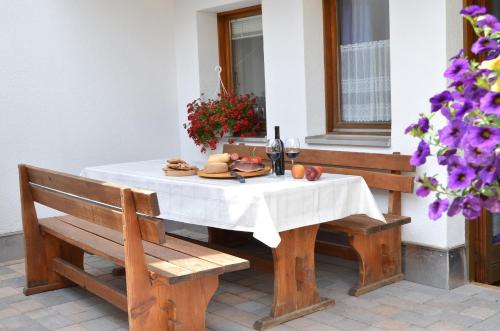 a table with a plate of bread and a bottle of wine at Haus Lena in Solda