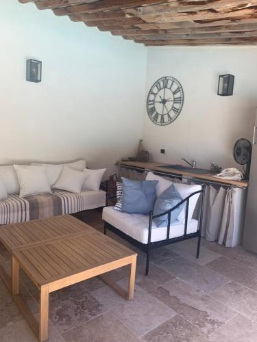 a living room with a couch and a clock on the wall at Lou Mas in Gordes