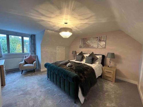 a bedroom with a large bed and a chair at Beautiful 4 bed semi rural house in Southam