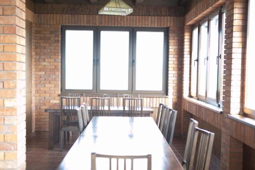 a dining room with tables and chairs and windows at Tulipan Hotel Aquapark in Vyshkove
