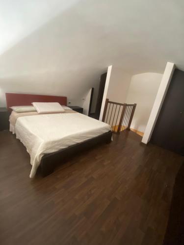 a bedroom with a bed and a wooden floor at Tiny Beach home in Bisceglie! in Bisceglie