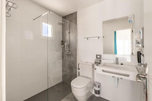 a bathroom with a toilet and a sink and a shower at Hostal Neptuno in Paguera