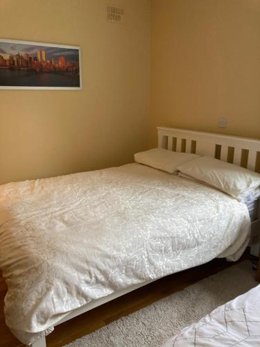 a bedroom with two beds with white sheets at Woodside in Nenagh
