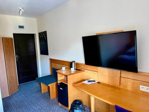 a hotel room with a large flat screen tv on the wall at LAS SŁUPSKI APARTAMENTY PREMIUM Wifi Netflix Smart TV50 Wysoka Jakość za Niską Cenę Zapraszamy in Słupsk