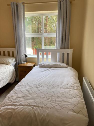 a bedroom with a white bed and a window at Woodside in Nenagh