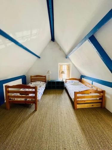 Cette chambre mansardée comprend 2 lits. dans l'établissement Une Chaumière à Port Manech', à Névez