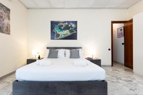 ローマにあるVATICAN Gregory Apartmentのベッドルーム1室(白い大型ベッド1台、テーブル2台付)