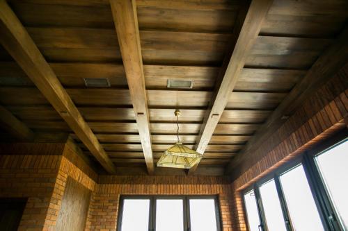 a wooden ceiling with a chandelier in a room at Tulipan Hotel Aquapark in Vyshkove