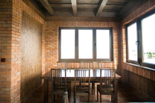 a dining room with a table and chairs and windows at Tulipan Hotel Aquapark in Vyshkove