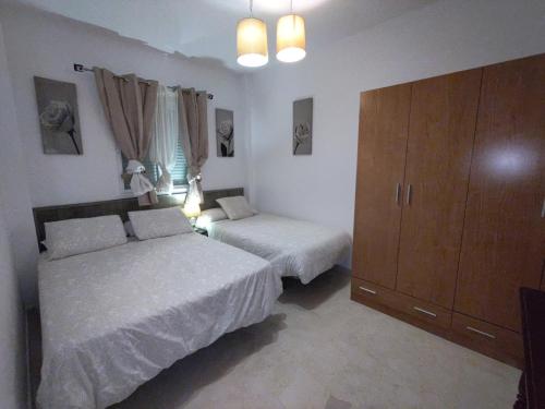- une chambre avec 2 lits et une grande armoire dans l'établissement APARTAMENTO SEVILLA, à Alcalá de Guadaira