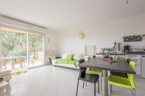 une cuisine et un salon avec une table et des chaises dans l'établissement Vue Marine - Appartement proche plage, à LʼÎle-Rousse