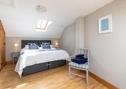 a bedroom with a large bed and a skylight at The Stables in Braunton