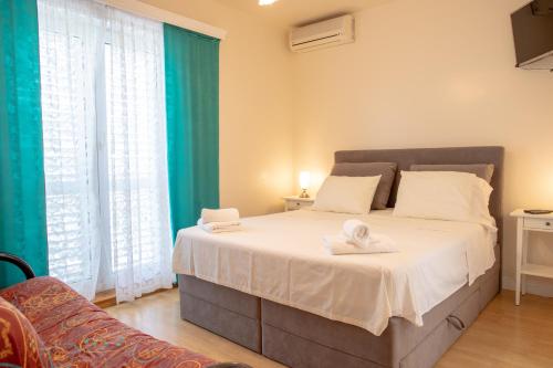 1 dormitorio con 1 cama grande y toallas. en Apartments Mijajov Dvor, en Sumartin