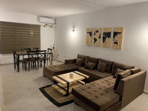ein Wohnzimmer mit einem Sofa und einem Tisch in der Unterkunft Dar Midoun Villa with pool in center city in Midoun