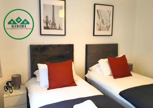 two beds sitting next to each other in a room at FW Haute Apartments at Wembley, Ground Floor 2 Bedroom and 1 Bathroom Flat, King or Twin beds and Double bed with FREE WIFI and FREE PARKING in London