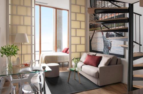 a living room with a couch and a spiral staircase at Eric Vökel Boutique Apartments - Riverfront Suites in Amsterdam