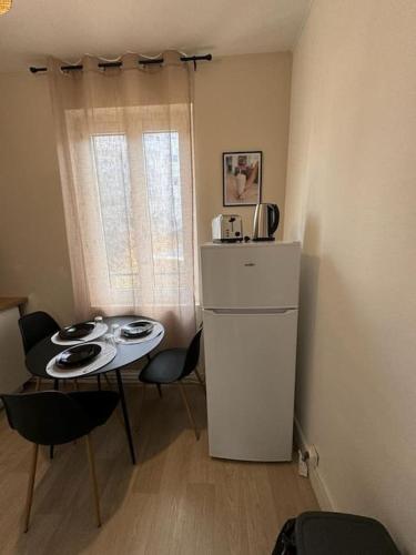 une petite cuisine avec une table et un réfrigérateur dans l'établissement L'Eco Studio, au Havre