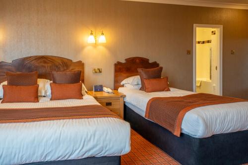 a hotel room with two beds in a room at Cairndale Hotel & Spa in Dumfries