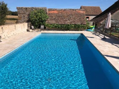a large blue swimming pool in front of a house at The Petit Prince Studio at Chateau Mareuil in Brigueuil-le-Chantre