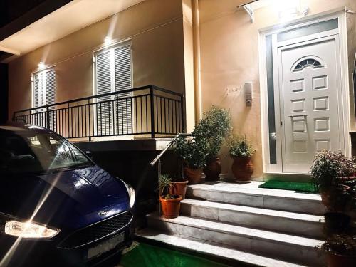 a car parked in front of a house with potted plants at MaFi Apartment in Ioannina