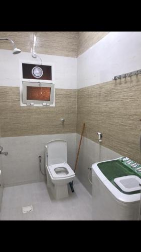 een badkamer met een toilet en een wastafel bij Athum أثوم in Ţāqah