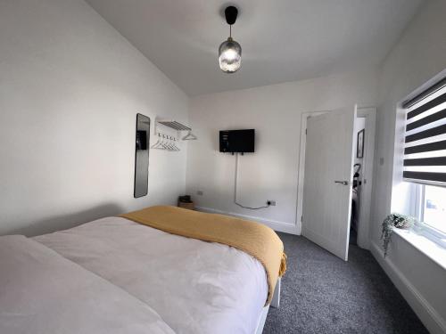 een slaapkamer met een bed en een tv aan de muur bij 50 Wood St in Burton upon Trent