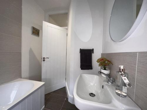 a white bathroom with a sink and a mirror at 50 Wood St in Burton upon Trent