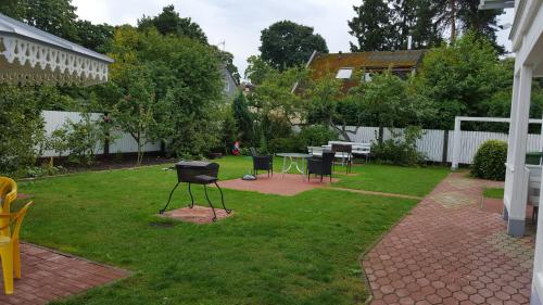 a yard with a grill and a table and chairs at Naiza Guesthouse and Apartments in Jūrmala
