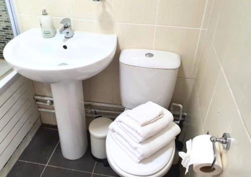 a bathroom with a white toilet and a sink at FW Haute Apartments at Wembley, Ground Floor 2 Bedroom and 1 Bathroom Flat, King or Twin beds and Double bed with FREE WIFI and PARKING in London