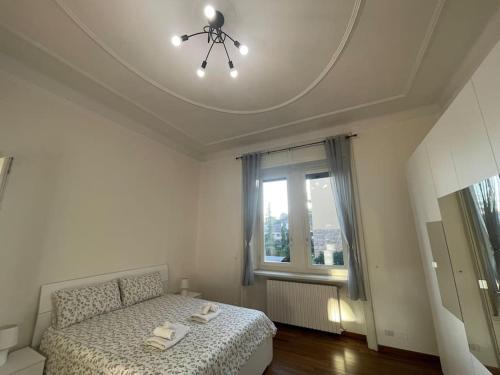 Habitación blanca con cama y ventana en BG Central President Suite con parcheggio - Vista Città Alta, en Bérgamo