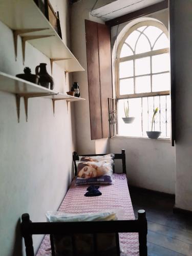 Camera piccola con tavolo e finestra di PHOENIX ATELIER a Salvador