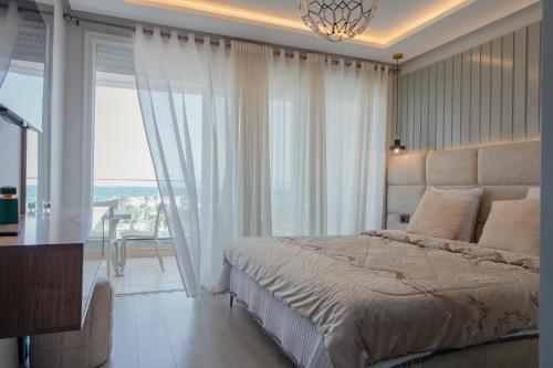 a bedroom with a large bed and a large window at DAR MAYSSA in El Hafsi