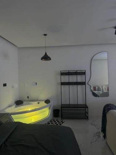 Habitación con baño con bañera amarilla. en استديو بجاكوزي وكراج دخول ذاتي, en Ar Ruqayyiqah