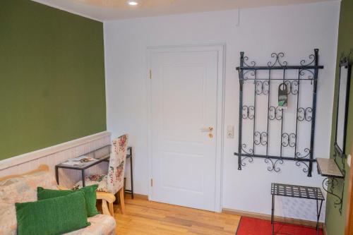 a living room with green walls and a white door at NATURION Hotel Hinterzarten in Hinterzarten