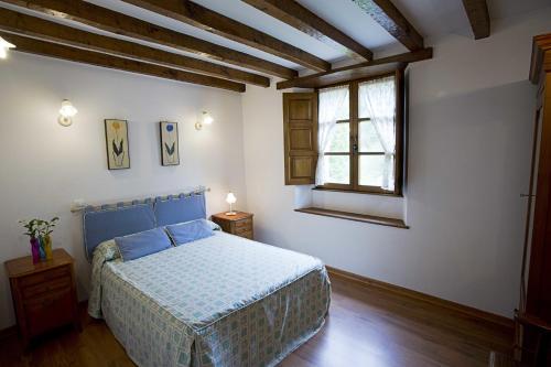 サンティリャーナ・デル・マルにあるApartamentos Tarrioのベッドルーム(青いベッド1台、窓付)