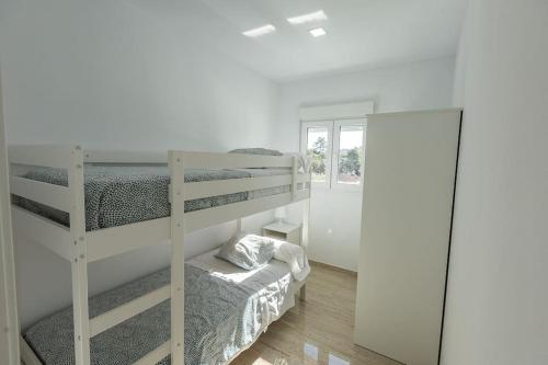 1 Schlafzimmer mit 2 Etagenbetten und einem Spiegel in der Unterkunft Villa Paraíso, exclusiva, todas las comodidades in Girona