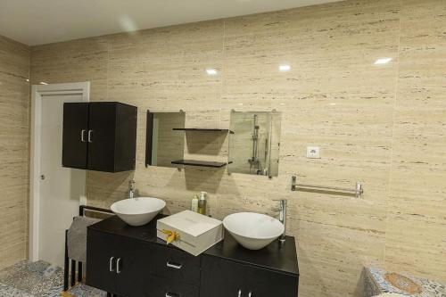 uma casa de banho com dois lavatórios brancos num balcão em Villa Paraíso, exclusiva, todas las comodidades em Girona