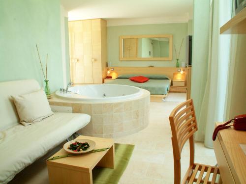 een woonkamer met een bad en een slaapkamer bij Color Alexandra Plaza Family Hotel in Riccione