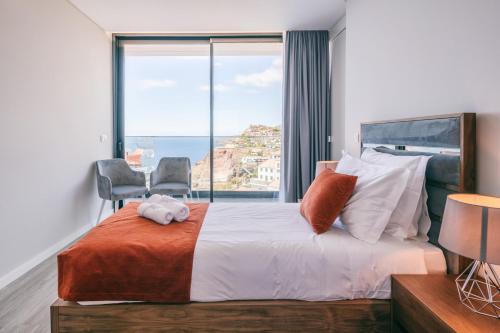 - une chambre avec un grand lit et une grande fenêtre dans l'établissement Villa Ocean Haven by AH, à Ribeira Brava