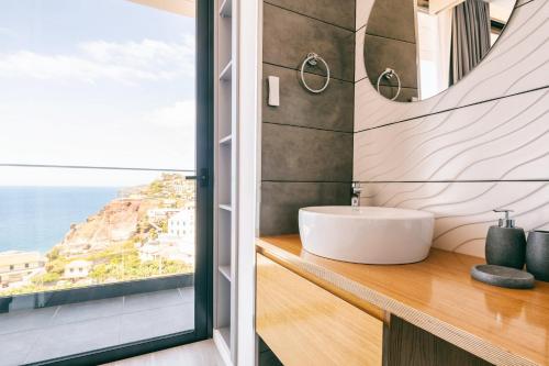 La salle de bains est pourvue d'un lavabo et offre une vue sur l'océan. dans l'établissement Villa Ocean Haven by AH, à Ribeira Brava