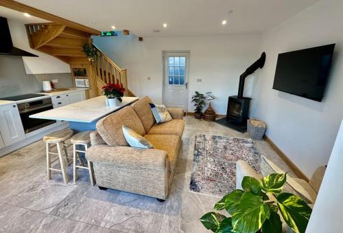 a kitchen and living room with a couch and a table at Peacock cottage in Ewenny