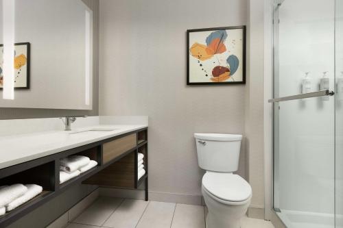 a bathroom with a toilet and a sink and a shower at Hilton Garden Inn Abilene in Abilene