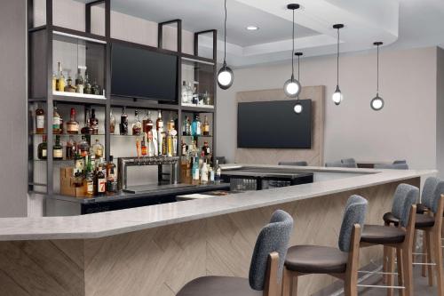 a bar in a hotel with chairs and a tv at Hilton Garden Inn Abilene in Abilene