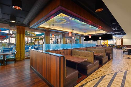 um restaurante com um bar com mesas e cadeiras em La Quinta by Wyndham Rapid City em Rapid City