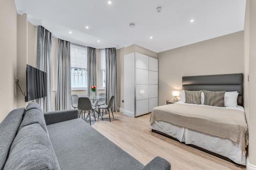 a hotel room with a bed and a couch at Cleveland Residences Chelsea in London