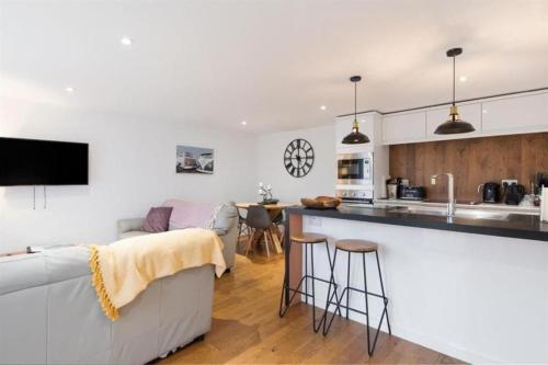 a living room and kitchen with a couch and a counter at The Hideout, Braunton, Devon in Braunton