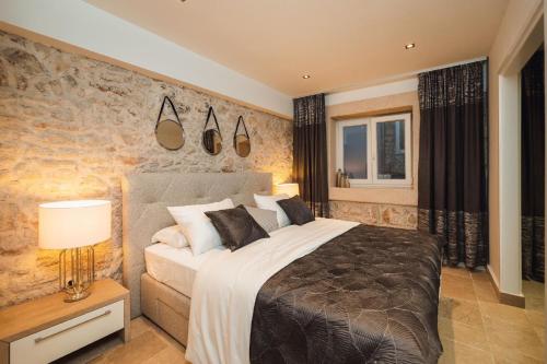 1 dormitorio con 1 cama grande y pared de piedra en Ferienhaus für 5 Personen und 1 Kind in Zaton bei Sibenik, Dalmatien, en Zaton