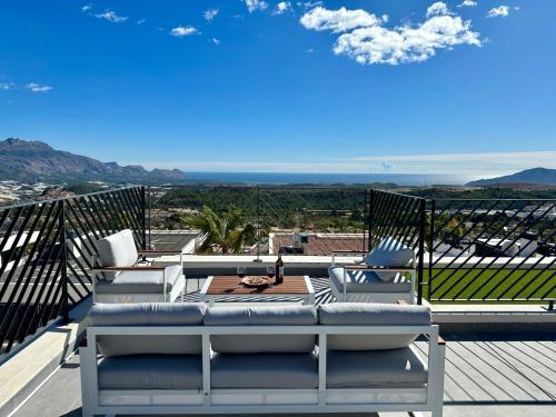 a patio with chairs and a table on a deck at Casa con piscina climatizada y vistas al mar in Polop