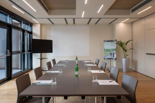 a conference room with a long table and chairs at UNA Hotels Bologna Fiera in Bologna